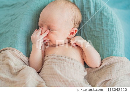 The baby is sleeping peacefully in his cozy nest. Newborn photo session captures the serene innocence and warmth of early moments The baby is sleeping peacefully in his cozy nest. Newborn photo session captures the serene innocence and warmth of early moments 118042320