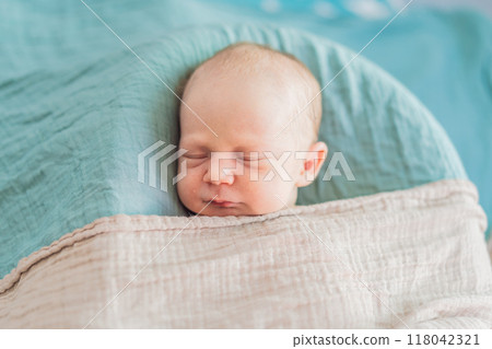 The baby is sleeping peacefully in his cozy nest. Newborn photo session captures the serene innocence and warmth of early moments The baby is sleeping peacefully in his cozy nest. Newborn photo session captures the serene innocence and warmth of early moments 118042321