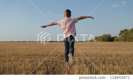 boy child running across field playing airplane flight dream, creative child play, escape game outdoor, child's dream fligh, kid fun running, imaginative child play, field freedom boy, dream game run 118042671