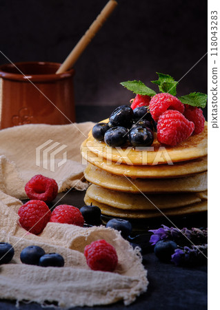 pancakes with berries and honey on dark background pancakes with berries and honey on dark background 118043283