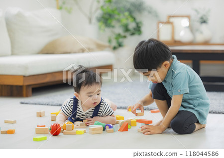 A 4-year-old boy plays with a crawling baby A 4-year-old boy plays with a crawling baby 118044586