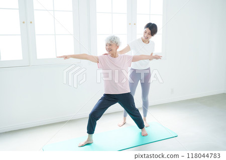 做瑜珈的高級婦女和教練 做瑜珈的高級婦女和教練 118044783