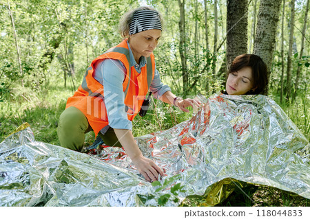 Covering unconscious tourist with foil Covering unconscious tourist with foil 118044833