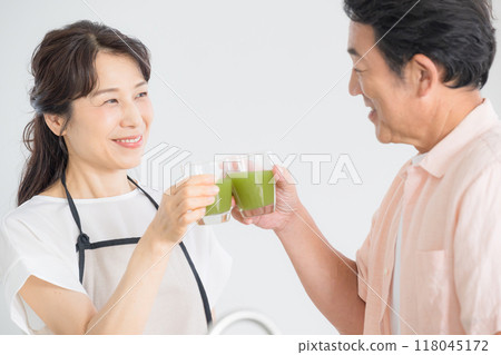 一位老人在廚房裡拿著綠色果汁，關心自己的健康的特寫醫療保健形象 118045172