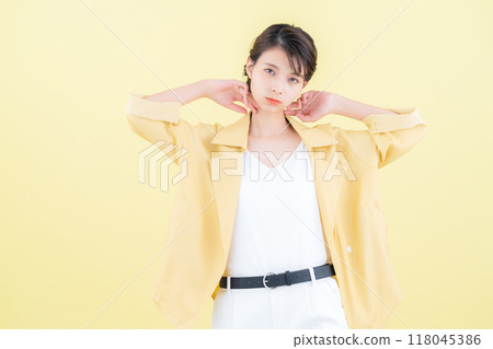 穿著黃色背景夾克擺姿勢的年輕女子 118045386