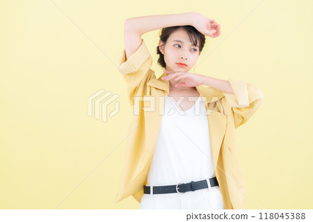 穿著黃色背景夾克擺姿勢的年輕女子 118045388