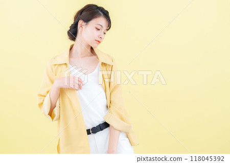 穿著黃色背景夾克擺姿勢的年輕女子 118045392