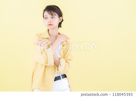 穿著黃色背景夾克擺姿勢的年輕女子 118045393