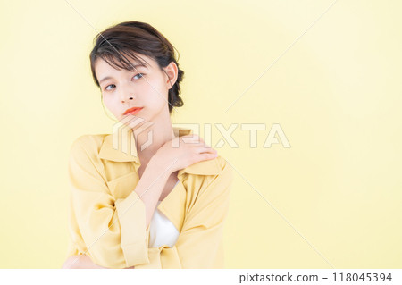 穿著黃色背景夾克擺姿勢的年輕女子 118045394