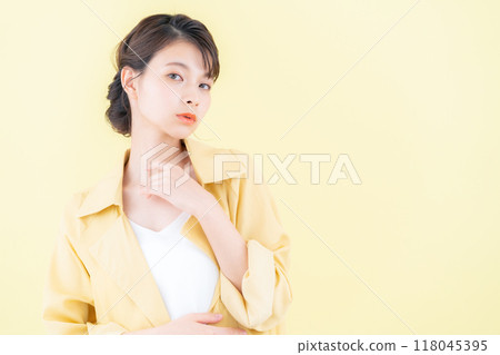 穿著黃色背景夾克擺姿勢的年輕女子 118045395