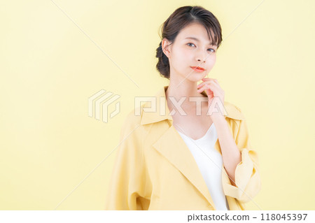 穿著黃色背景夾克擺姿勢的年輕女子 118045397
