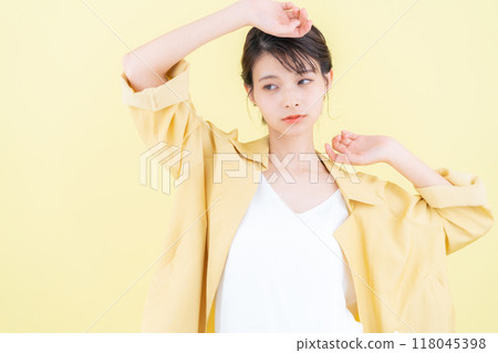 穿著黃色背景夾克擺姿勢的年輕女子 118045398
