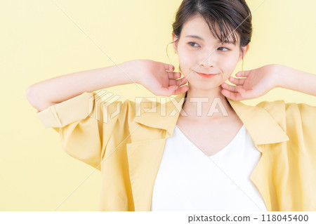 穿著黃色背景夾克擺姿勢的年輕女子 118045400