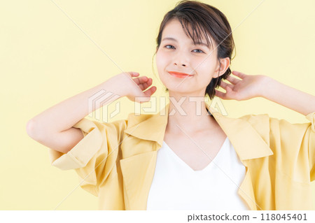 穿著黃色背景夾克擺姿勢的年輕女子 118045401