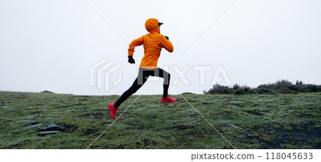 Woman trail runner cross country running to high altitude mountain peak Woman trail runner cross country running to high altitude mountain peak 118045633