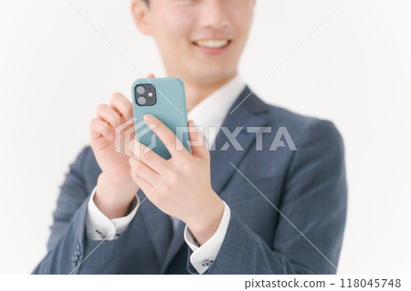 A businessman operating a smartphone 118045748