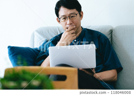 一個操作帶沙發的電腦的男人 118046008