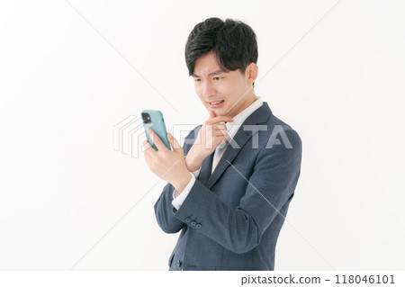 Business man worried about seeing a smartphone Business man worried about seeing a smartphone 118046101