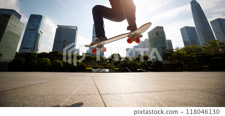 Asian woman skateboarder skateboarding in modern city Asian woman skateboarder skateboarding in modern city 118046130