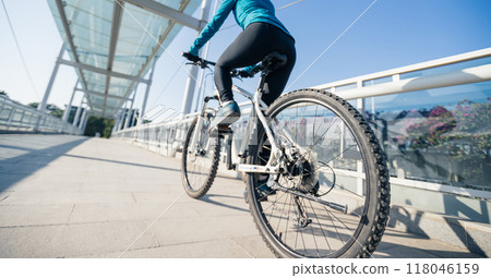 Woman riding bike at city on sunny day Woman riding bike at city on sunny day 118046159