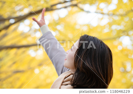 Young woman enjoying autumn leaves hunting 118046229