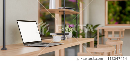 A laptop on a wooden table in a contemporary Scandinavian coffee shop seating area. 118047434