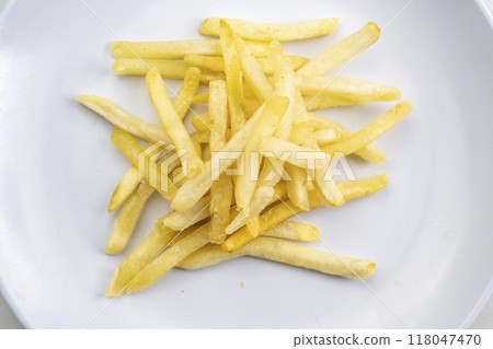 A plate of french fries sits on a white table 118047470