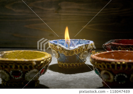 A row of small red and blue candles are lit, creating a warm A row of small red and blue candles are lit, creating a warm 118047489