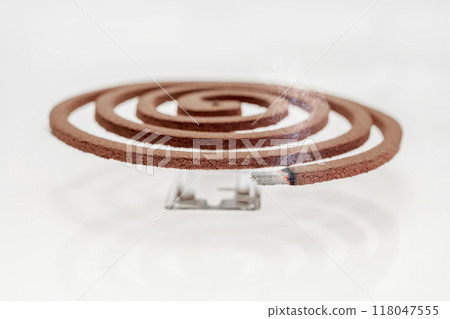 A mosquito coil with smoke coming out of it A mosquito coil with smoke coming out of it 118047555