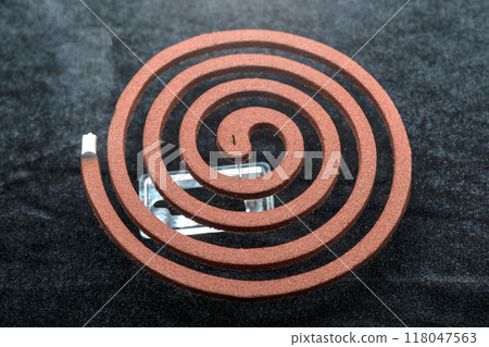 A mosquito coil with smoke coming out of it A mosquito coil with smoke coming out of it 118047563