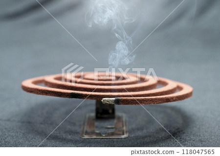 A mosquito coil with smoke coming out of it A mosquito coil with smoke coming out of it 118047565