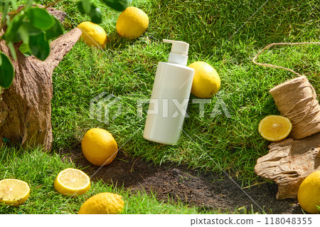 White cosmetic bottle displayed on green grass with fresh lemons and dry twigs. Mockup scene for cosmetic with natural vitamin C from lemon extract. Unlabeled for design White cosmetic bottle displayed on green grass with fresh lemons and dry twigs. Mockup scene for cosmetic with natural vitamin C from lemon extract. Unlabeled for design 118048355