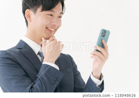 Smiling business person looking at smartphone Smiling business person looking at smartphone 118048616