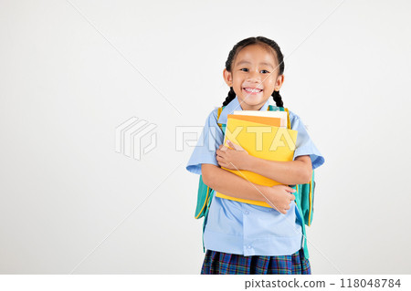 Portrait Asian smiling young girl kids kindergarten holding backpack and hugging books studio shot isolated white background, happy cute little schoolgirl wears school uniform, back to school concept Portrait Asian smiling young girl kids kindergarten holding backpack and hugging books studio shot isolated white background, happy cute little schoolgirl wears school uniform, back to school concept 118048784