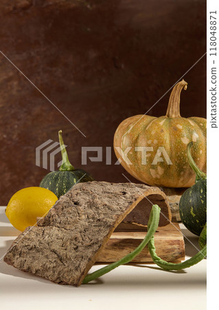Festive autumn decor from pumpkins and dry twigs on brown rustic background. Creative photo for advertising with empty space for product presentation  118048871