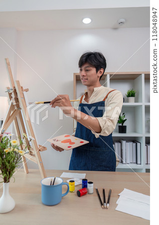 Young artist painting in a personalized studio space Young artist painting in a personalized studio space 118048947