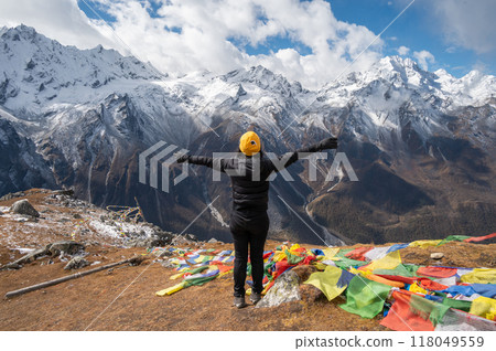 Rear view of female tourist raised her hands after reached to top of Tsergo Ri (4,990m) the high point on the Langtang valley trek of Nepal. 118049559