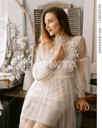 Attractive woman, wearing vintage style pastel dress indoor. 118050150