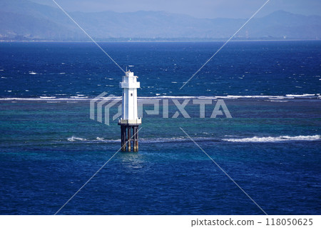 A solitary white lighthouse stands tall near Pantai Senggigi, Lombok, Indonesia. A solitary white lighthouse stands tall near Pantai Senggigi, Lombok, Indonesia. 118050625