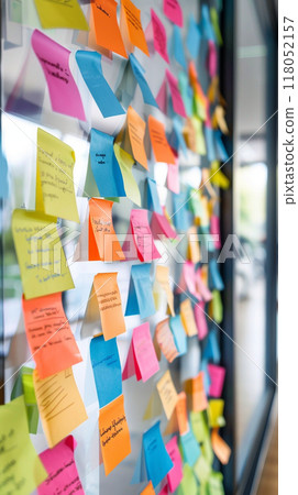 A wall covered in colorful sticky notes with various words 118052157
