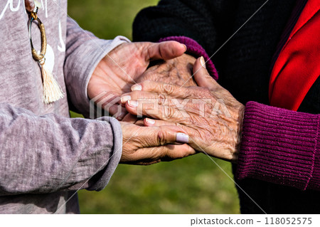 Affection and tenderness of a granddaughter to her grandmother. Traits of aging on the hands Affection and tenderness of a granddaughter to her grandmother. Traits of aging on the hands 118052575