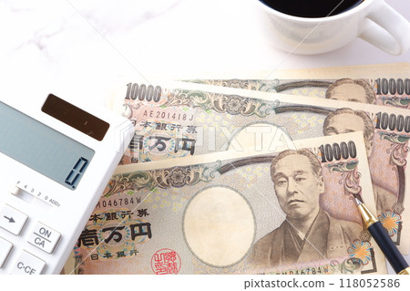 A 10,000 yen bill with a portrait of Yukichi Fukuzawa, a calculator, a pen, and a coffee cup with freshly brewed coffee. 118052586
