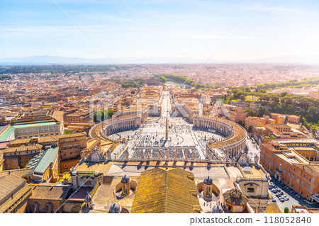 Visitors gather in Saint Peter's Square, marveling at the grandeur of St. Peter's Basilica and enjoying the scenic beauty of Vatican City during a serene sunset Visitors gather in Saint Peter's Square, marveling at the grandeur of St. Peter's Basilica and enjoying the scenic beauty of Vatican City during a serene sunset 118052840