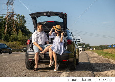 Couple Enjoying a Sunny Day by the Car Couple Enjoying a Sunny Day by the Car 118053228