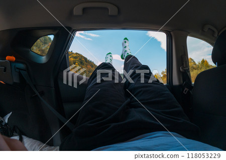 Relaxing in a Car with Legs Out the Window Relaxing in a Car with Legs Out the Window 118053229