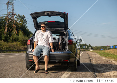 Young Man Relaxing by His Car on a Sunny Day Young Man Relaxing by His Car on a Sunny Day 118053230