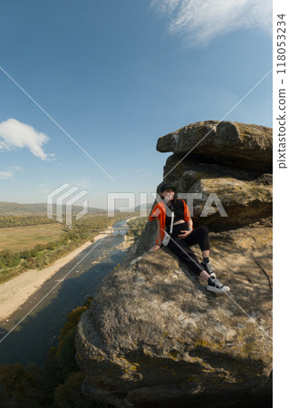 Woman on Rock Overlooking Scenic River Woman on Rock Overlooking Scenic River 118053234