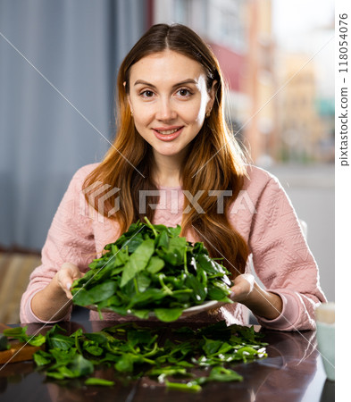 Happy girl making delicious spinach salad closeup Happy girl making delicious spinach salad closeup 118054076