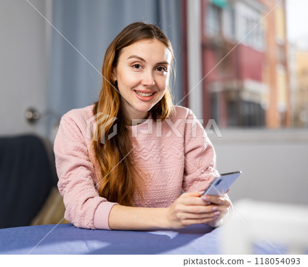 Young woman is texting with someone on a mobile phone 118054093