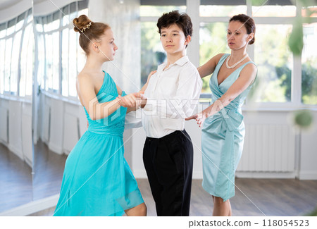 Motivated adolescent ballroom dancers practicing dance moves in studio 118054523
